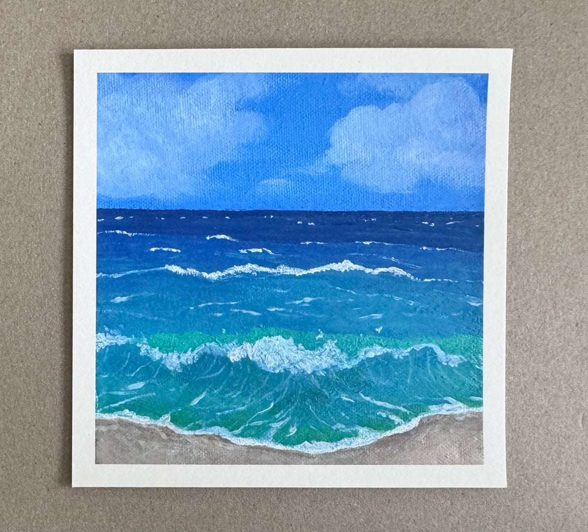 4.25in x 4.25in art print with white borders of a painting of a beach scene with blue ocean waves and sky