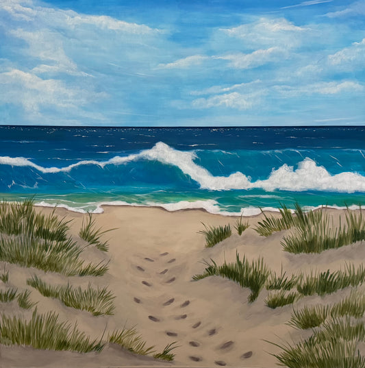 Photo of a square painting of a beach scene with a sandy foreground, green dune grass, a blue ocean with white waves, and a bright blue sky with clouds.