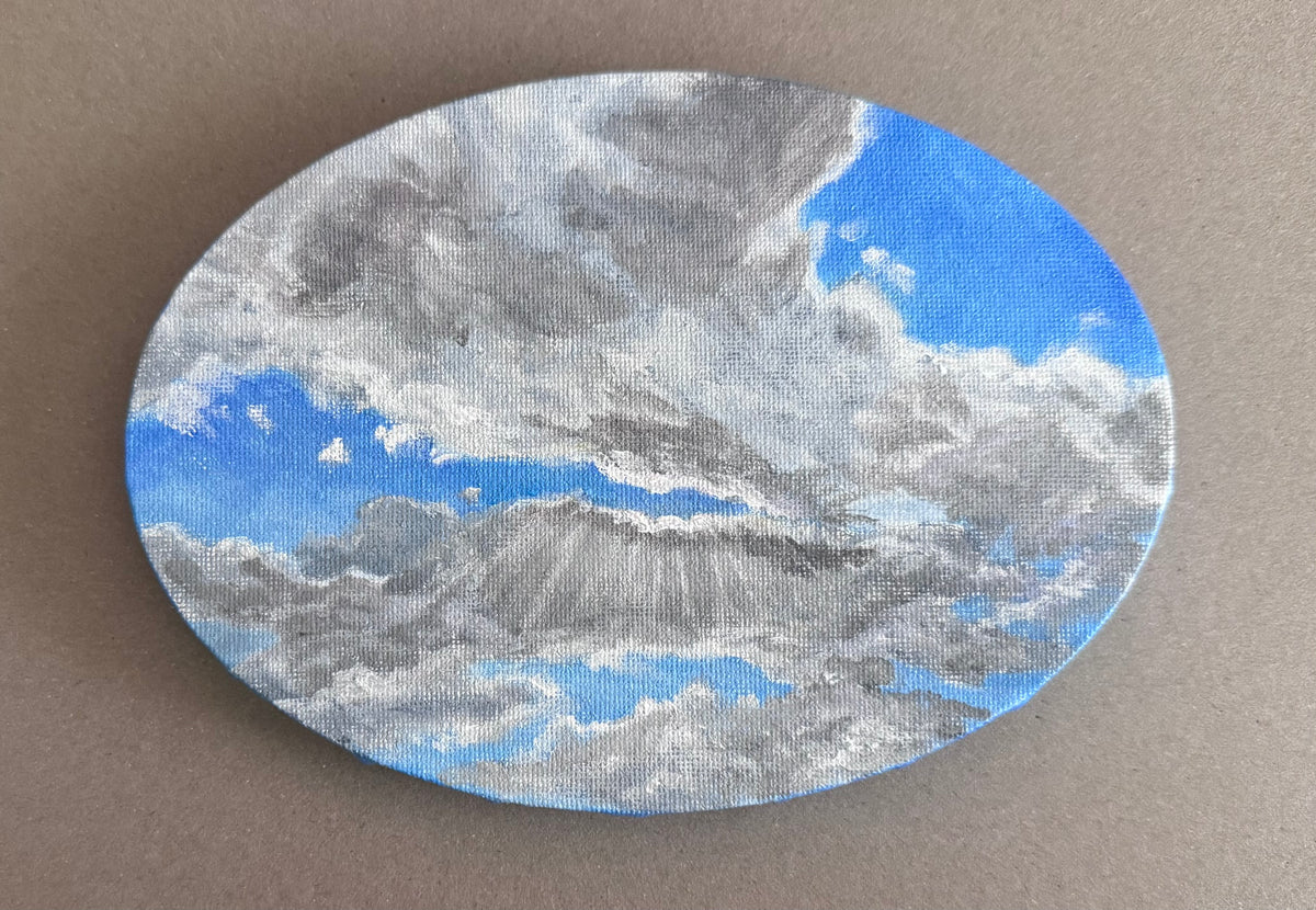 Photo of a 5in x 7in oval painting of clouds on canvas 