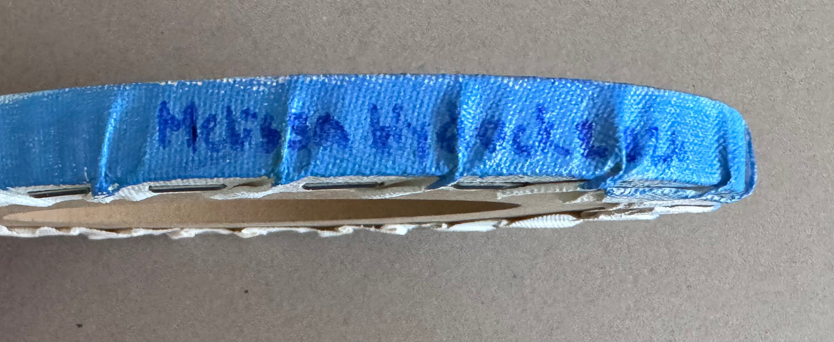 Signature of artist in blue paint that reads, "Melissa Hydock" 