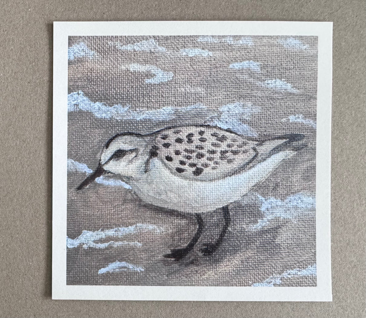 4.25in x 4.25in art print with white borders of a sandpiper standing on the beach